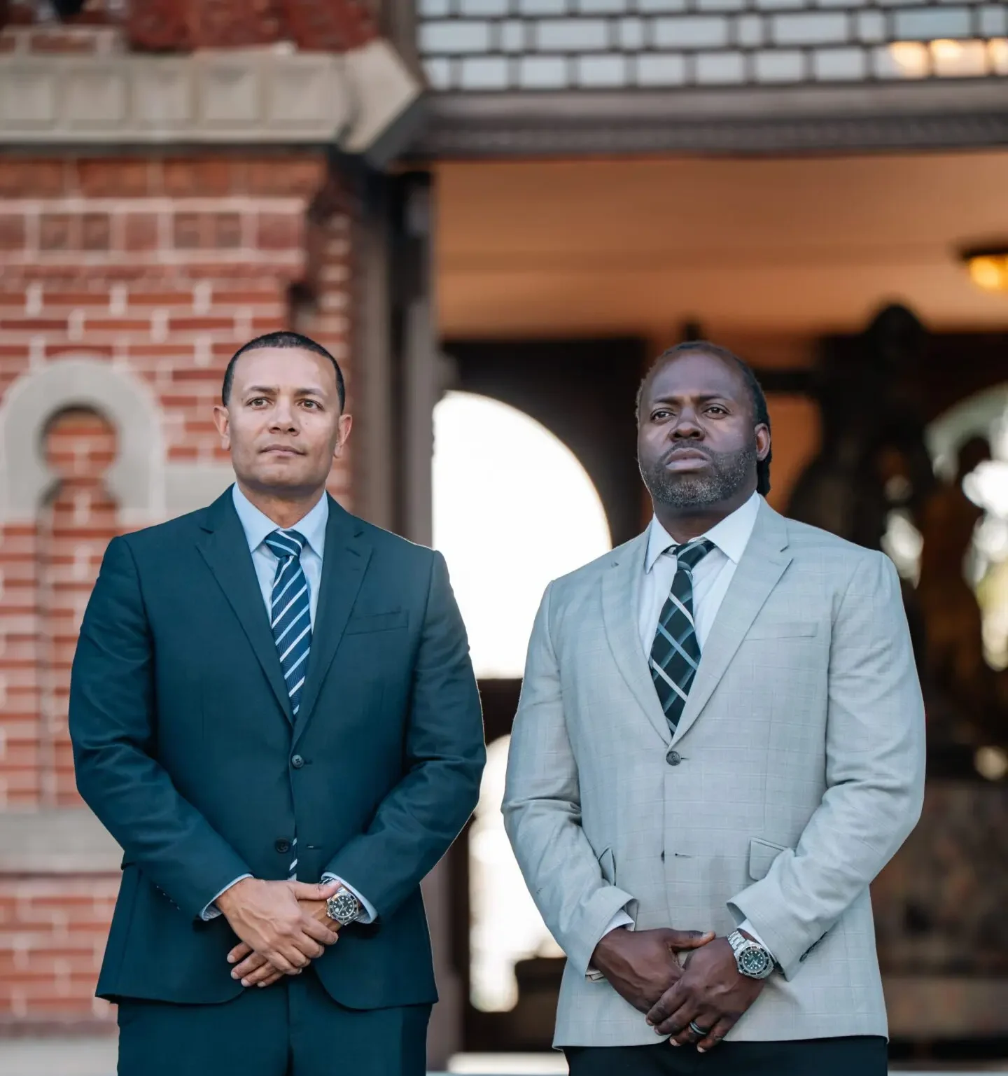 Two men in suits standing solemnly